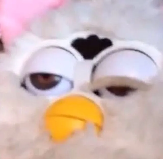 A Furby face, the creature seems tired or wasted.
